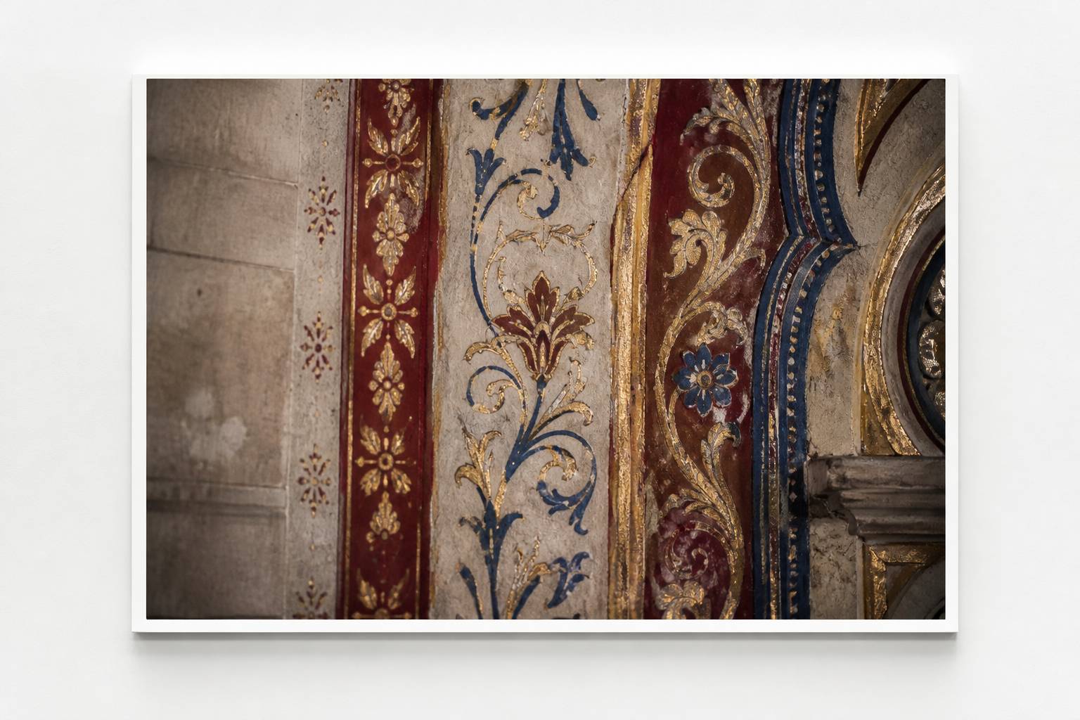 Détail d'une fresque polychrome dorée et bleue sur un mur de chapelle