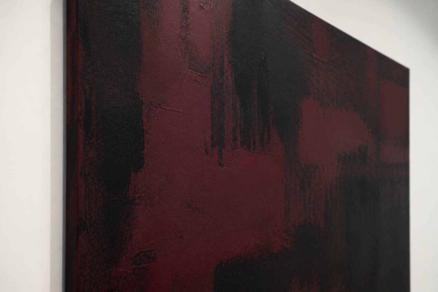 Surface d'une toile abstraite aux aplats de couleurs sombres superposées