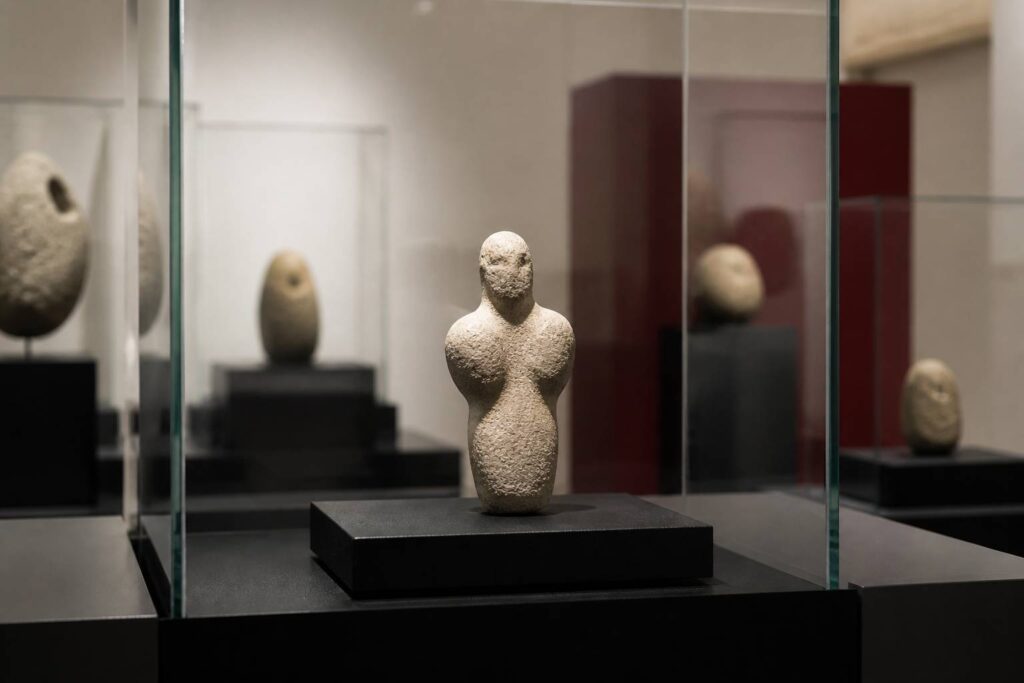 Petite sculpture préhistorique en calcaire dans une vitrine de musée